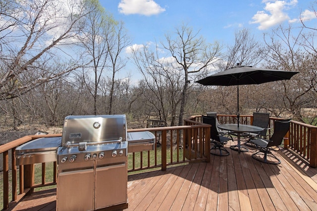 wooden deck with outdoor dining space and grilling area