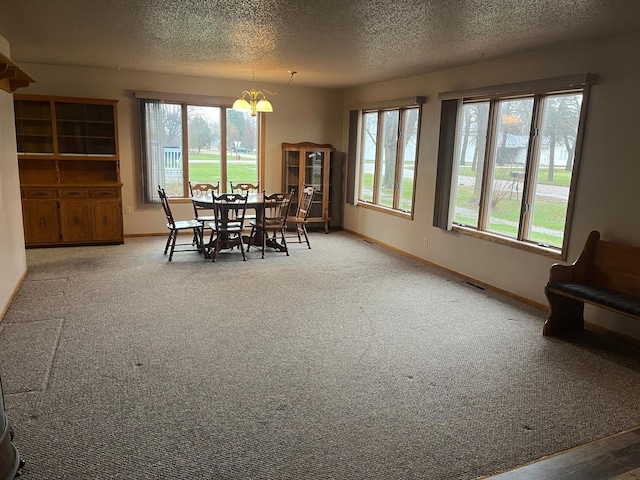 130 2nd St NE, Mcintosh, MN 56556 - carpeted dining space with an inviting chandelier, a textured ceiling, and a wealth of natural light