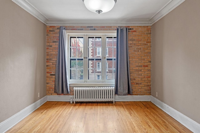 1820 1st Ave S Unit 102, Minneapolis, MN 55403 - empty room with radiator heating unit, crown molding, and light wood-style flooring