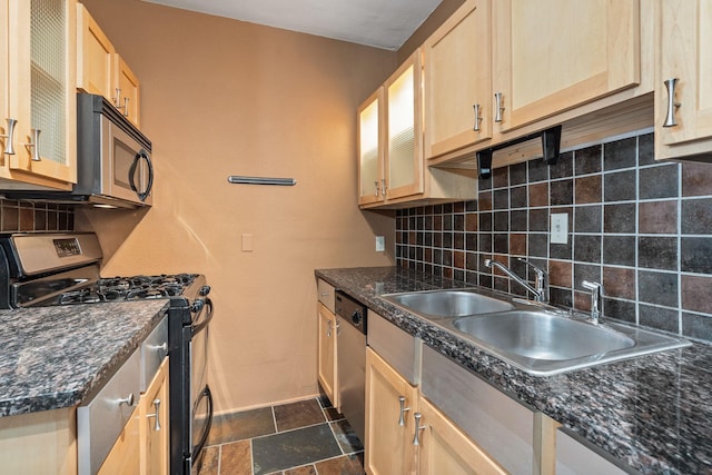 1820 1st Ave S Unit 102, Minneapolis, MN 55403 - kitchen featuring a sink, backsplash, baseboards, dark countertops, and appliances with stainless steel finishes