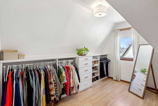 spacious closet with light wood finished floors and lofted ceiling