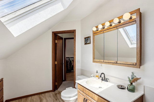 bathroom featuring vanity, toilet, and lofted ceiling with skylight