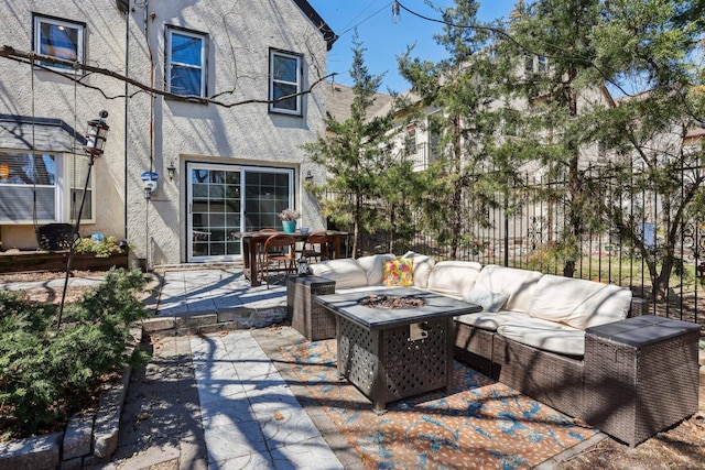 view of patio / terrace featuring an outdoor living space with a fire pit and fence