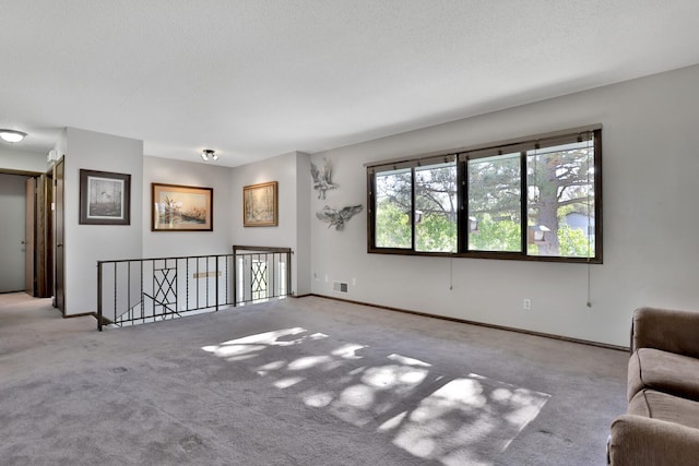 unfurnished living room with carpet flooring, baseboards, and visible vents