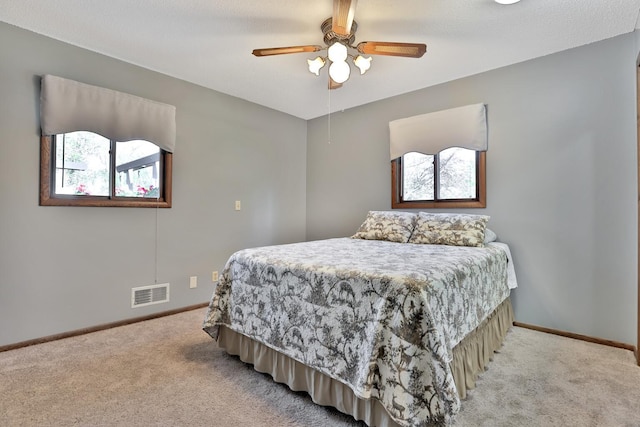 bedroom featuring baseboards, ceiling fan, light carpet, and visible vents
