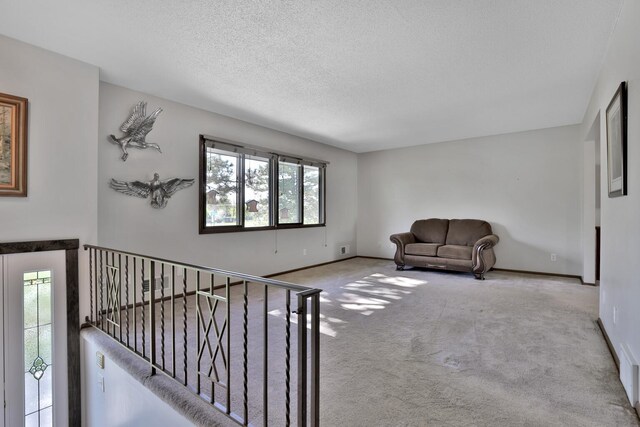 unfurnished living room with baseboards, a textured ceiling, and carpet