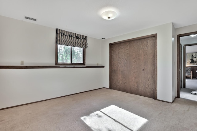 unfurnished bedroom with a closet, visible vents, and carpet floors