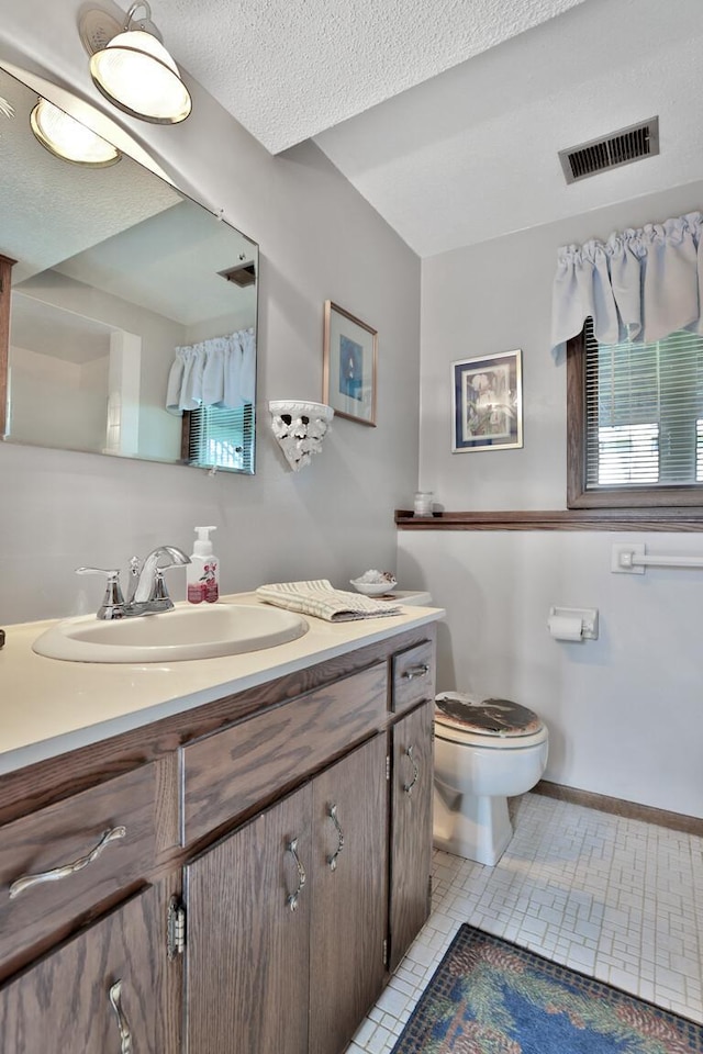 bathroom featuring toilet, visible vents, baseboards, tile patterned flooring, and vanity