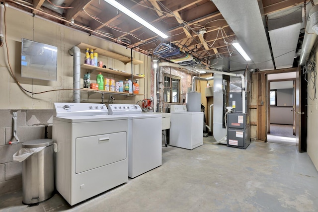 laundry room with laundry area, independent washer and dryer, heating unit, and water heater