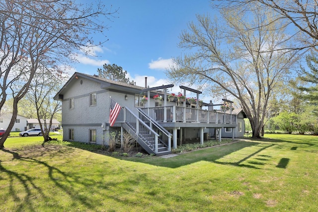 back of property with a wooden deck, stairs, and a lawn