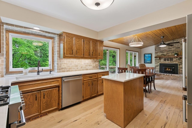 3861 Westbury Dr, Eagan, MN 55123 - kitchen featuring appliances with stainless steel finishes, brown cabinets, light wood-style floors, a center island, and light countertops