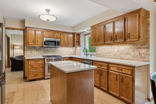 3861 Westbury Dr, Eagan, MN 55123 - kitchen featuring stainless steel appliances, a sink, brown cabinets, light countertops, and light wood finished floors