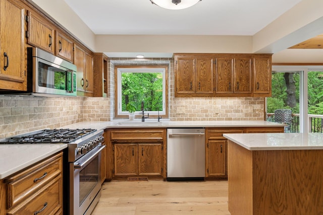 3861 Westbury Dr, Eagan, MN 55123 - kitchen with appliances with stainless steel finishes, a sink, brown cabinetry, and plenty of natural light