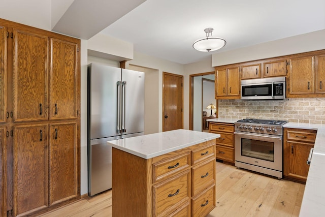 3861 Westbury Dr, Eagan, MN 55123 - kitchen with high end appliances, brown cabinetry, light wood-style flooring, and decorative backsplash