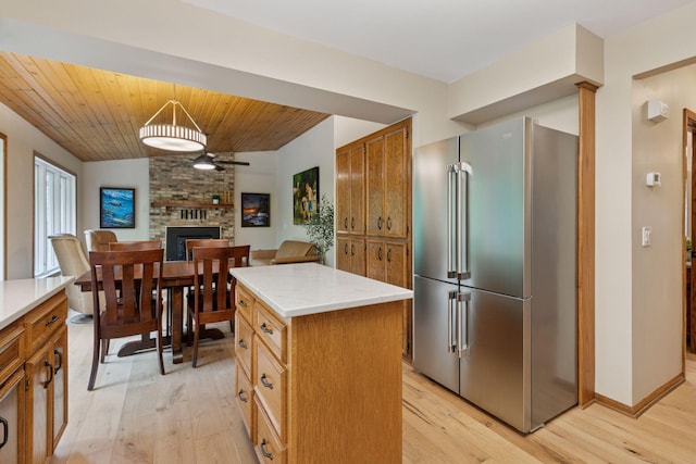 3861 Westbury Dr, Eagan, MN 55123 - kitchen featuring high end refrigerator, light wood finished floors, a brick fireplace, open floor plan, and a center island