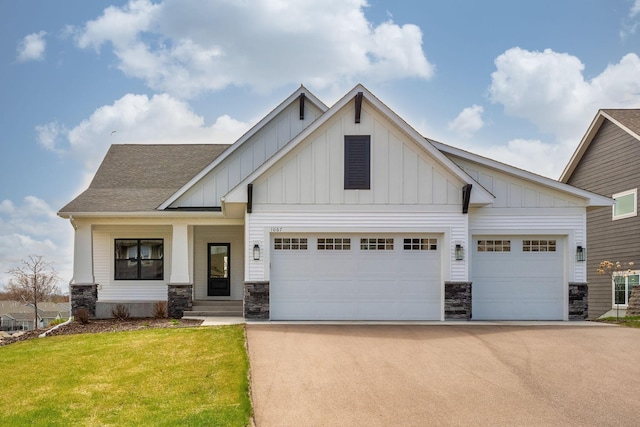 view of front facade featuring a garage, board and batten siding, driveway, and a front lawn