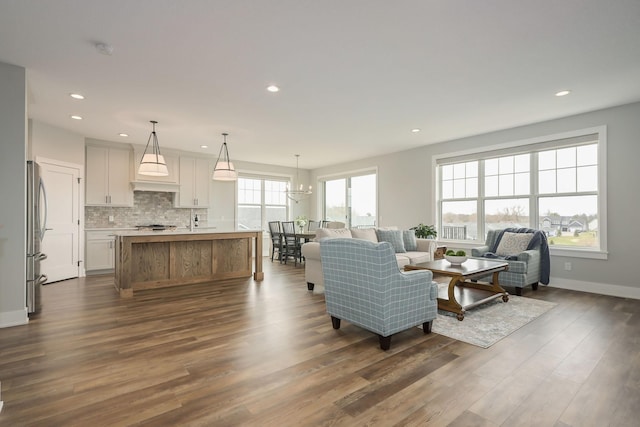 living room with dark wood-style flooring, baseboards, and recessed lighting