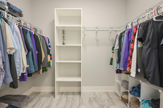 walk in closet with wood finished floors