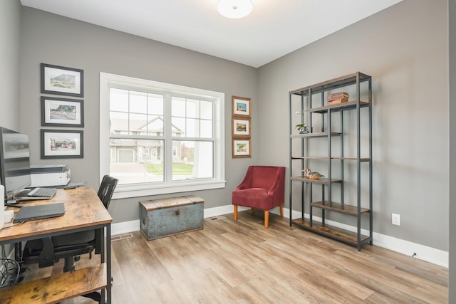 office with baseboards and light wood-style flooring