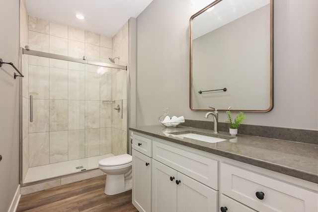 full bath with a shower stall, wood finished floors, vanity, toilet, and recessed lighting