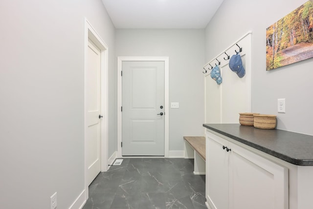 mudroom with baseboards and marble finish floor