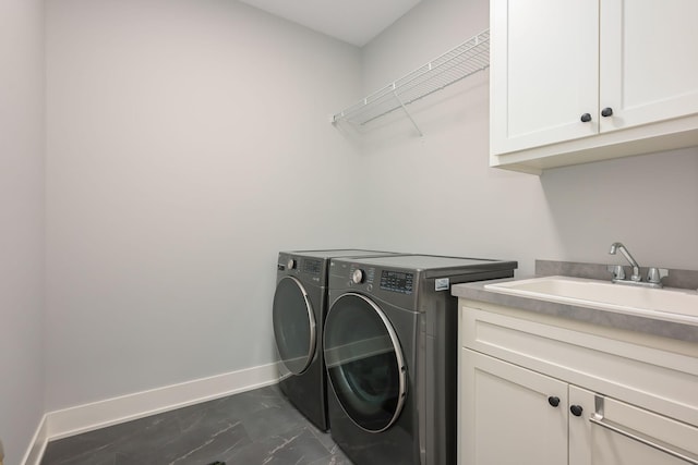 laundry room featuring marble finish floor, washing machine and dryer, baseboards, a sink, and cabinet space