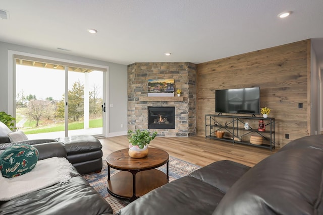 living room featuring visible vents, wood walls, wood finished floors, and recessed lighting