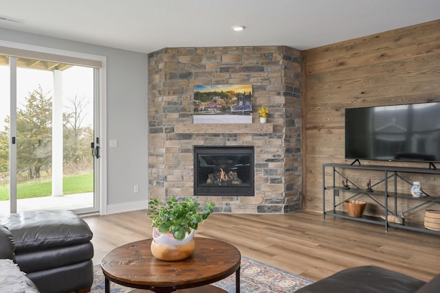 living area with visible vents, baseboards, wood finished floors, and a fireplace