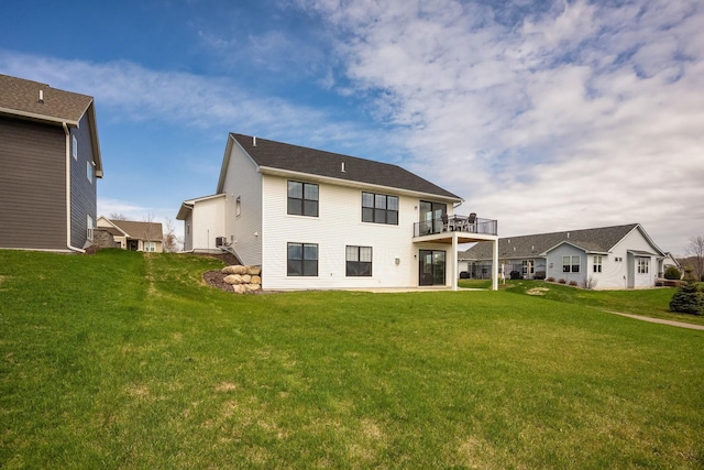 back of property featuring a lawn, a patio area, and a balcony
