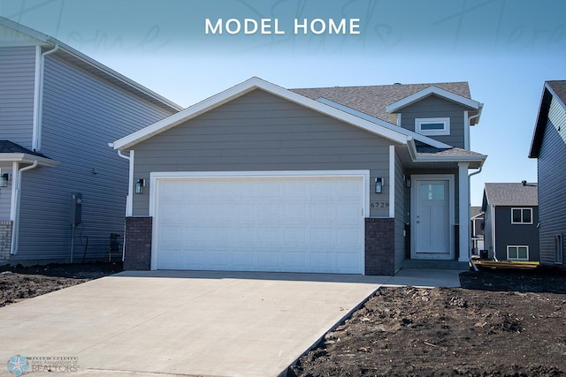 view of front of house with brick siding, an attached garage, and concrete driveway