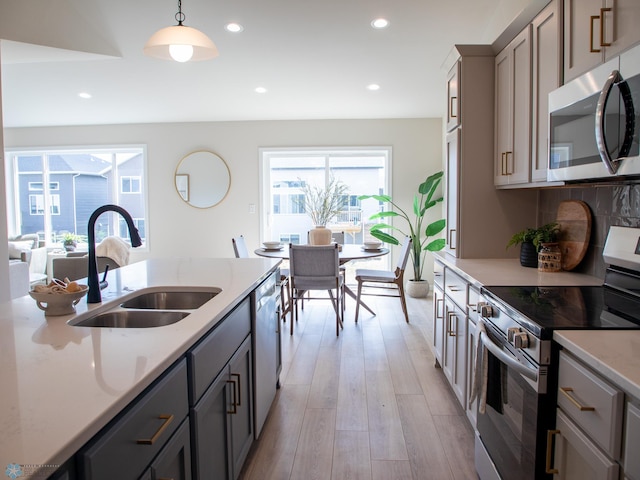 kitchen with recessed lighting, a sink, light wood-style flooring, gray cabinetry, and stainless steel appliances