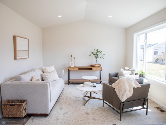 living area with baseboards, visible vents, a healthy amount of sunlight, and wood finished floors
