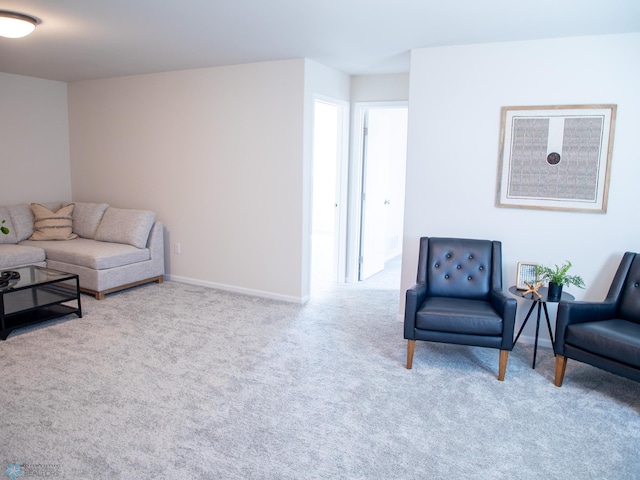 sitting room with baseboards and carpet
