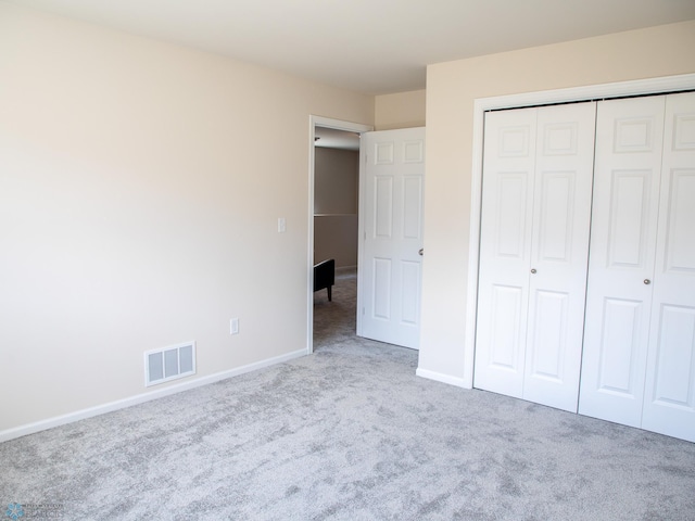 unfurnished bedroom with visible vents, carpet flooring, baseboards, and a closet