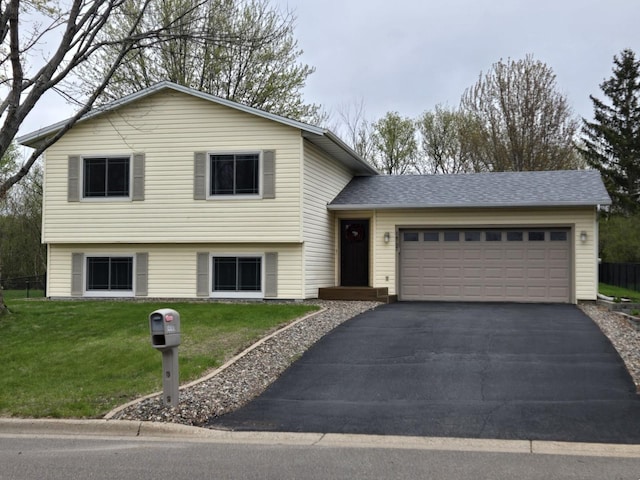 tri-level home with a front yard, an attached garage, and driveway