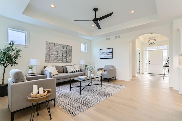 4501 Overlook Dr, Bloomington, MN 55437 - living area with a ceiling fan, visible vents, arched walkways, light wood finished floors, and a tray ceiling