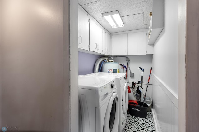 laundry area with separate washer and dryer, water heater, cabinet space, and a wainscoted wall
