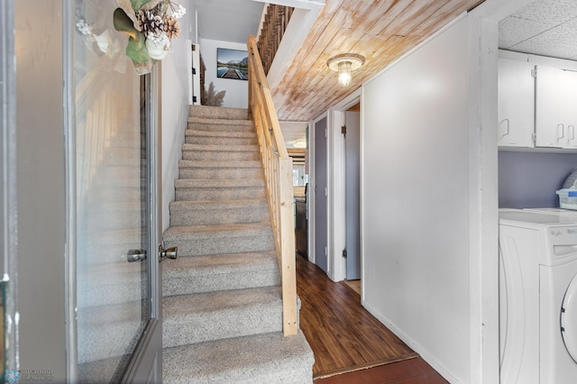stairs with baseboards, wood finished floors, and washer / clothes dryer