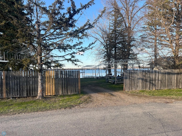 view of gate featuring fence and a water view
