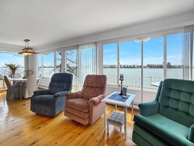 interior space with a baseboard heating unit, a water view, and a wealth of natural light