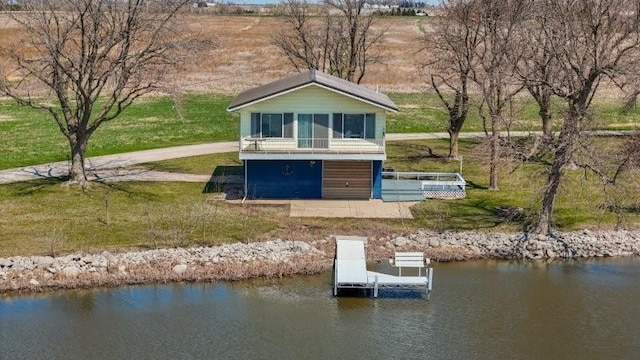 back of house featuring a yard and a water view