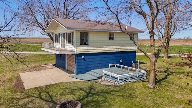 back of house featuring a yard and a balcony