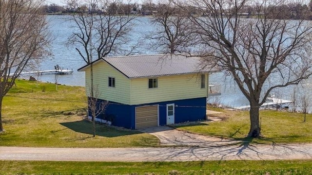 view of front of property with a front lawn, metal roof, and a water view