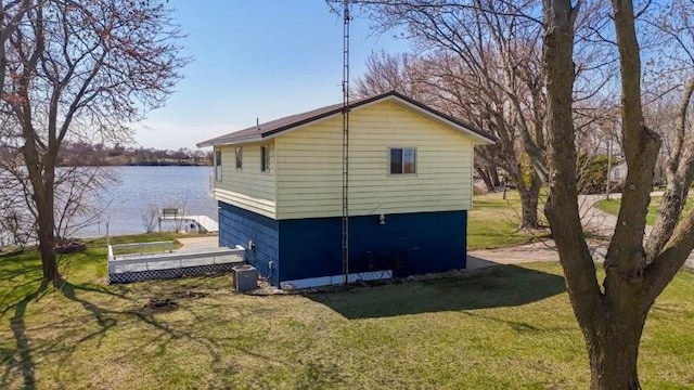 view of property exterior with a yard and a water view