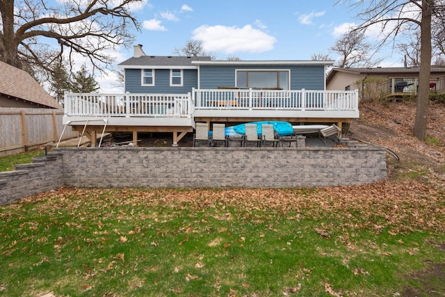 back of house with fence, a chimney, and a deck