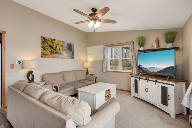 living area featuring baseboards, a ceiling fan, and light carpet