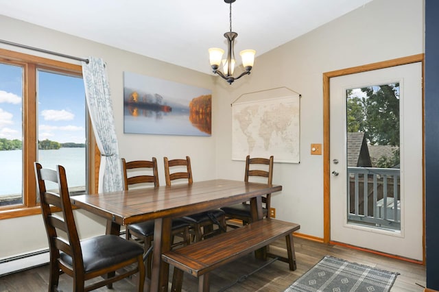 dining area featuring baseboard heating, wood finished floors, a water view, baseboards, and a notable chandelier
