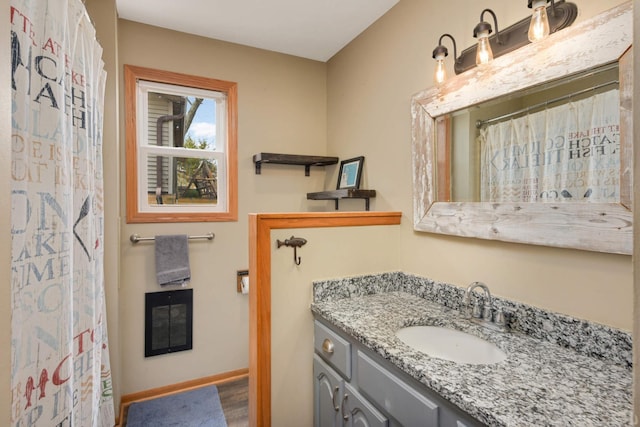 bathroom featuring baseboards, vanity, and wood finished floors