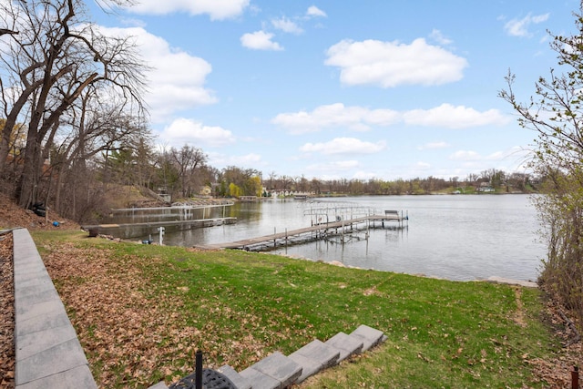 view of dock featuring a lawn and a water view