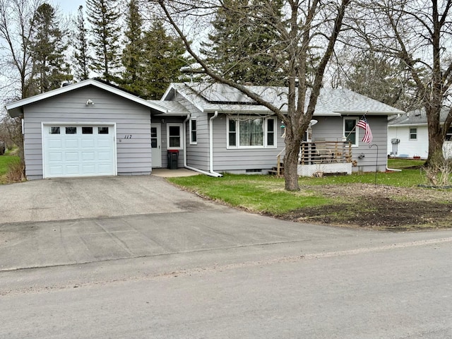 ranch-style home with an attached garage, a front yard, and aphalt driveway
